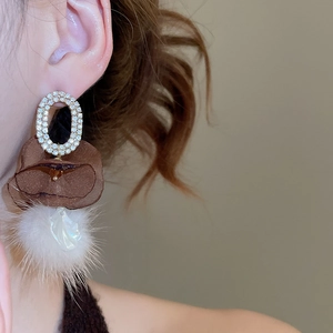 Close-up of vintage oval mesh fur ball drop earrings with shiny crystal inlays