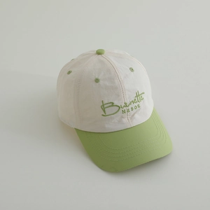 Close-up of green Burnette NESOE 3D embroidery on a beige kids' baseball cap