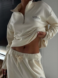Close-up of cream fleece tracksuit set showing half-zip design and soft fabric texture