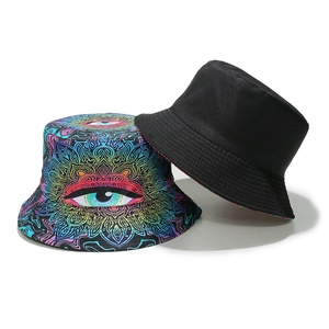 Detail of reversible bucket hat featuring vibrant evil eye mandala print and solid black side