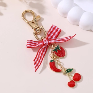 Detail of keychain with red checkered bow, strawberry, chili, and cherry charms