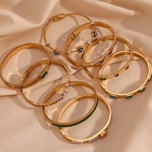Detail of 18K gold-plated stainless steel bracelets with colorful zircon stones on silk