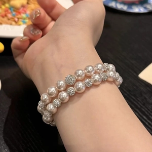 Close-up of double-layer pink pearl bracelet with shimmering rhinestone-studded balls