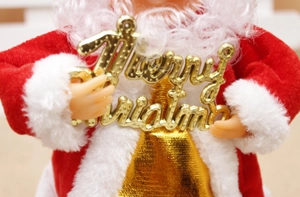 Detail of Santa Claus holding a Merry Christmas sign with red velvet and gold accents