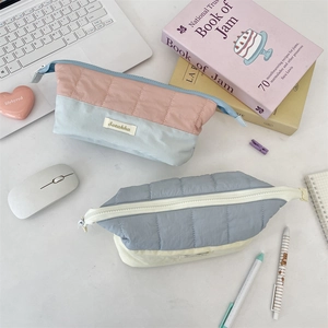 Close-up of quilted color-block stationery pouches with Sorakka woven labels and zippers