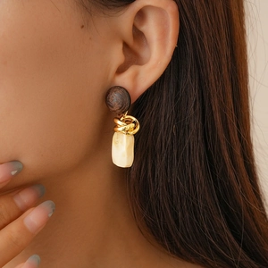 Close-up of a model wearing retro resin geometric earrings in brown and beige tones