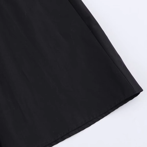 Gros plan des coutures et de la texture du tissu sur une jupe midi plissée noire