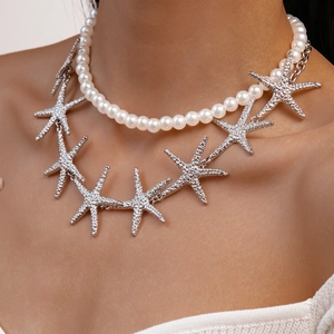 Close-up of double-layer necklace with white pearls and silver textured starfish pendants