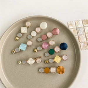 Set of 8 colorful geometric resin and metal hair clips displayed on a ceramic plate