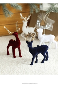 Detailed view of flocked Christmas reindeer ornaments in red and navy with glitter antlers