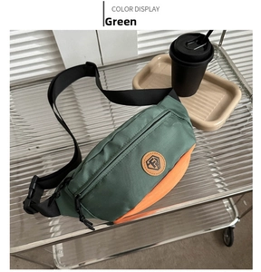 Detail view of water-resistant nylon waist bag in dark green and orange with shield logo