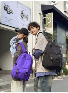 Vista trasera de modelos con mochilas grandes impermeables para negocios en lila y negro