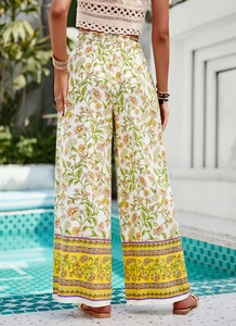 Détail d'un pantalon large à fleurs avec bordure bohème vu de l'arrière