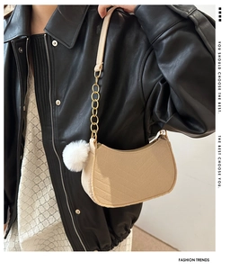 Détail du sac bandoulière en feutre beige avec surpiqûres en V et chaîne dorée