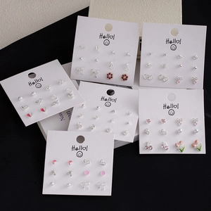 Macro detail of mixed earring sets with cherry, heart, and pearl designs on display cards