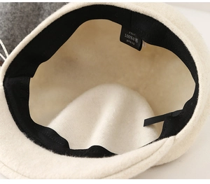 Detail shot of the interior sweatband and 100% wool label on off-white newsboy hat