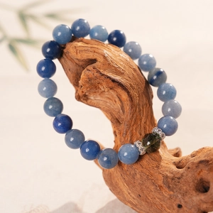 Macro detail of blue crystal beaded bracelet on vintage brown wood decorative base