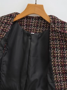 Detailed close-up of textured tweed fabric in black and pink with gold metallic threads