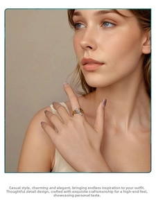Detailed view of silver and gold feather wing ring worn on finger showing adjustable band