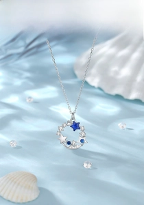 Close-up of S925 silver necklace with blue star gem on light blue satin background