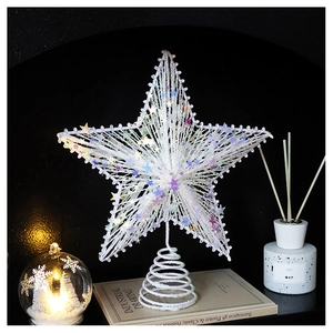 Close-up of sparkling star Christmas tree topper with sequins and warm LED lighting on books