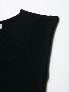 Detail shot of black knitted top featuring a V-neckline and high-density ribbed texture