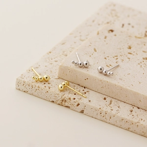 Detailed view of cluster beaded s925 silver stud earrings in gold and silver finishes