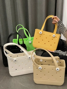 Close-up of EVA rubber beach tote bags in various colors showing hole texture and b-logo studs