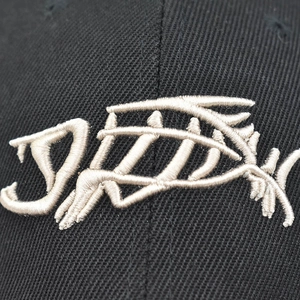 Close-up of 3D fish bone embroidery on a high-density black cotton baseball cap