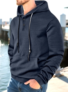 Detailed view of dark blue hoodie showing its subtle herringbone texture and buttoned neck