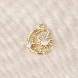 Detailed view of gold plated crescent moon and star charm set with sparkling cubic zirconia