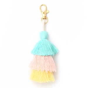 Detailed view of handmade three-layer cotton tassel in blue, pink, and yellow with gold clasp