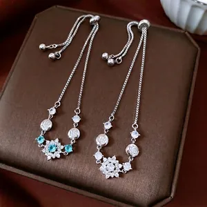 Silver snowflake earrings with blue zircon crystals on a luxury jewelry box display