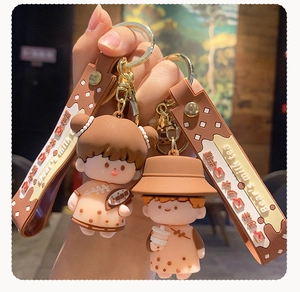 Detail of cute bubble tea couple keychains with brown silicone straps and gold rings
