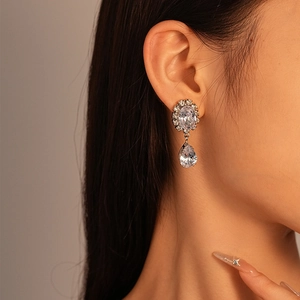 Gros plan d'une femme portant des boucles d'oreilles pendantes en zircon argenté en forme de larme