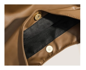 Detail of magnetic snap closure on vintage dark brown leather shoulder tote bag
