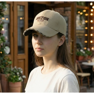 Detail of BOSTON 1630 embroidery and SPORT trim on beige cotton baseball cap