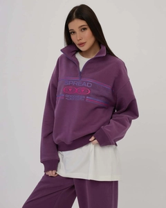 Detail of purple half-zip sweatshirt set with white SPREAD GOODNESS graphic print