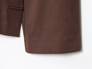 Detailed close-up of dark brown twill fabric with visible double stitching and texture