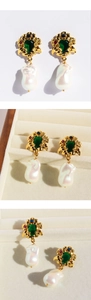 Macro detail of emerald gemstones and white baroque pearl on vintage gold earrings