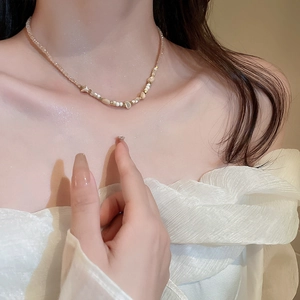 Collier chic de perles en nacre et cristal porté par un mannequin sous une lumière douce