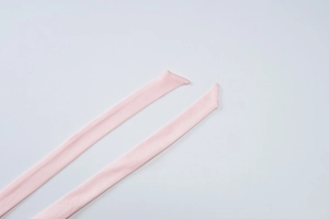 Macro view of light pink polyester ribbon straps with fine stitched edge detailing