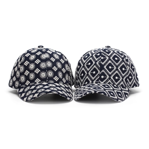 Dos gorras de béisbol azul marino con intrincados patrones de bordado blanco estilo étnico