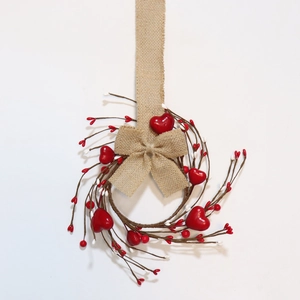 Close-up of heart berry candle ring with rustic linen bow for table decoration