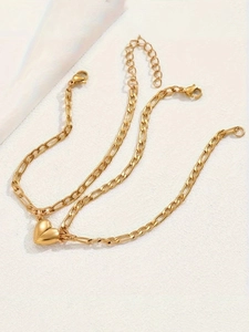 Macro view of golden stainless steel Cuban heart bracelet with lobster clasp on fabric