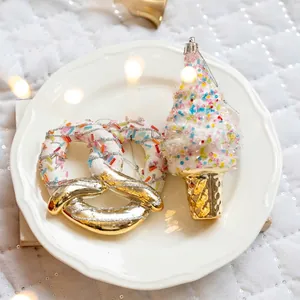 Christmas tree ornaments featuring glittery pretzel and ice cream cone shapes in white and gold