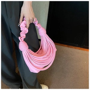 Close-up of pink pleated crescent shoulder bag with unique knotted multi-strand handles