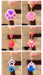Detail shots of glitter resin earrings featuring cat head and paw designs in various colors