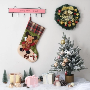 Detail of Christmas stocking with 3D reindeer and snowman patch on green felt