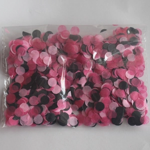 Close-up of pink and black round tissue paper confetti in a clear plastic package